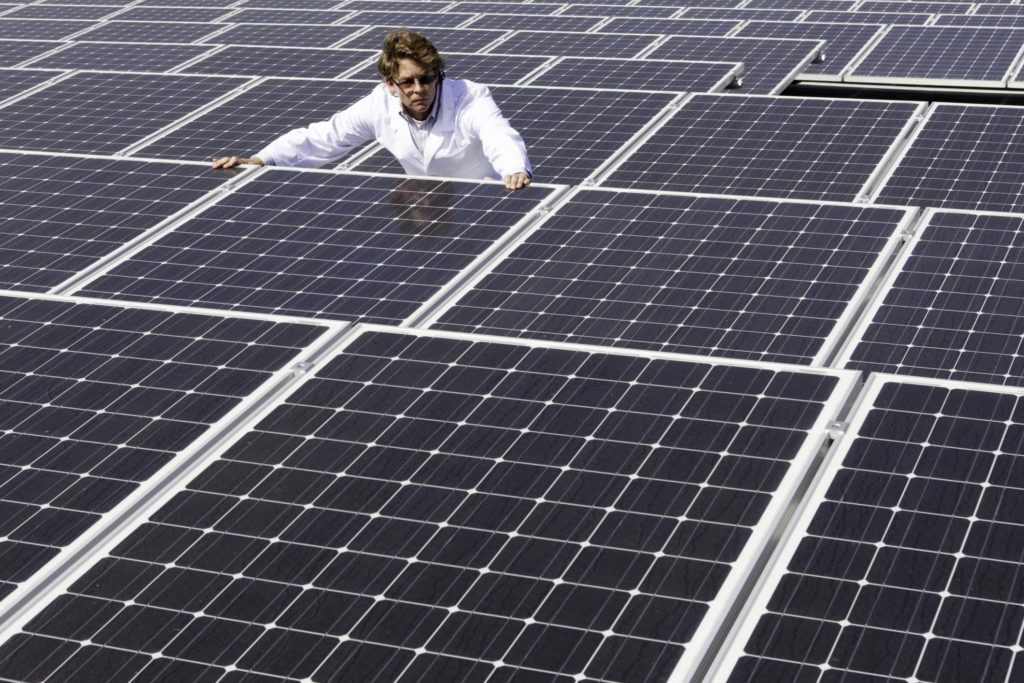 man inspecting solar panels