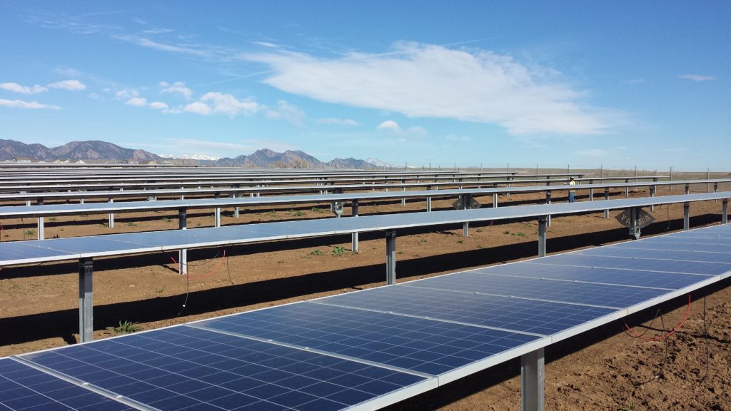 Rows of solar panels in front of mountains