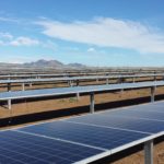Rows of solar panels in front of mountains