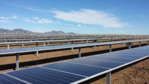 Rows of solar panels in front of mountains