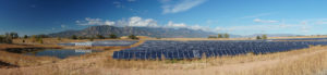 Wide shot of a solar farm in front of mountains