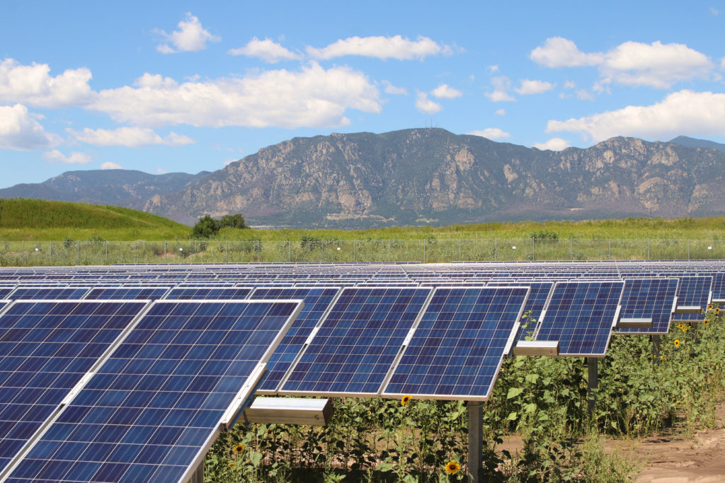 Rows of solar panels by mountains