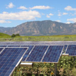 Rows of solar panels by mountains