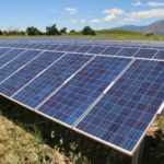 Rows of solar panels by mountains
