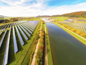 Rows of solar panels with a river running through it