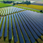 A solar garden managed by SunShare sits in a field on a sunny day as SunShare explains what a solar garden actually is